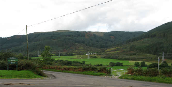 Original photograph of a valley road with pylons, prior to the woodland photo-montage